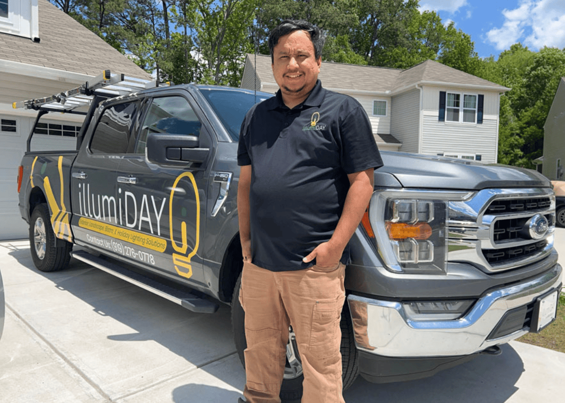 Picture of business owner in front of branded truck